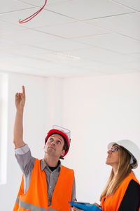 Architect showing ceiling to colleague