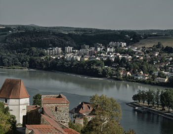 High angle view of townscape by lake against sky