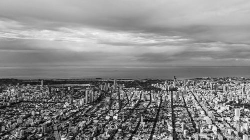 Crowd on field against sky in city