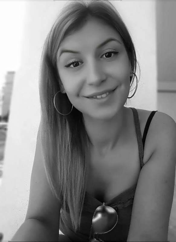 PORTRAIT OF YOUNG WOMAN STANDING ON WALL