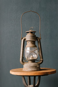 Close-up of lantern on table against wall