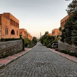 Surface level of footpath amidst buildings against sky