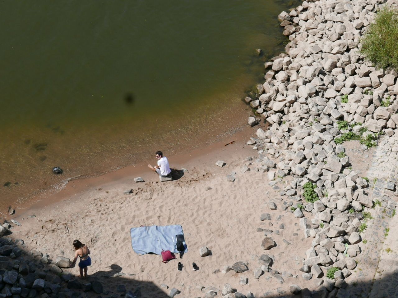 HIGH ANGLE VIEW OF PEOPLE SITTING ON SHORE