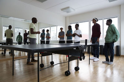 Coach listening to students during training session in games room