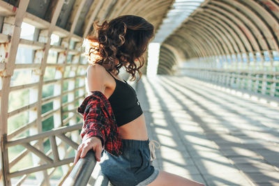 Side view of female athlete standing at footbridge