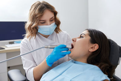 Female dentist examining patient at clinic
