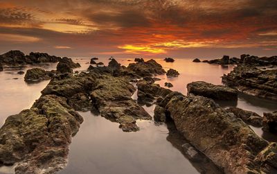 View of rocks on beach during sunset