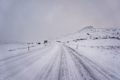 Snow covered landscape against sky