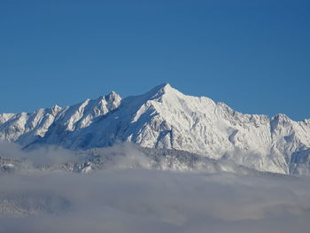 Scenic view of snowcapped mountains against clear blue sky