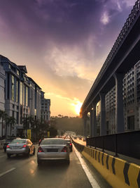 Vehicles on road at sunset