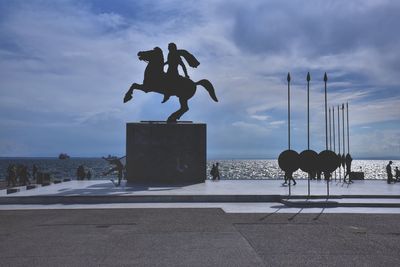 People on shore against sky