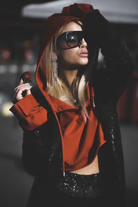 Young woman wearing sunglasses eating a strawberry