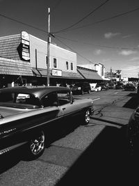 Cars on street in city against sky