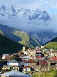 Aerial view of townscape and mountains against sky