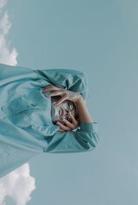 Close-up portrait of woman holding blue over white background