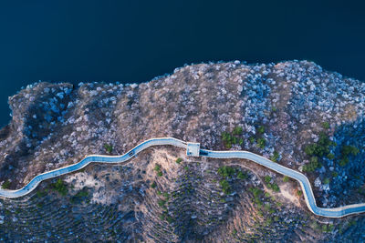 Aerial view of road on land against sea