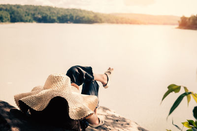 Rear view of woman sitting on the beach