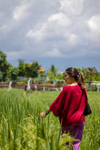 Woman standing on field against sky