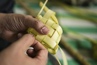 Weaving the coconut leaves making the ketupat, a traditional malay cuisine for the eid celebration.