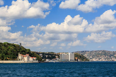 Buildings by sea against sky