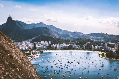 City at waterfront against cloudy sky