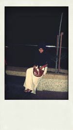 Side view of young woman sitting on floor