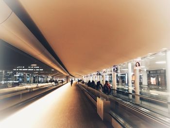 Blurred motion of train at illuminated railroad station in city