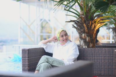 Portrait of woman sitting on chair , the world always looks brighter from behind a smile.