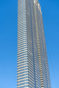 Low angle view of modern building against clear blue sky