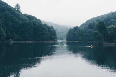 Scenic view of river by trees against sky