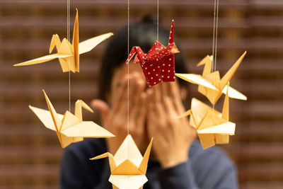 Close-up of hand holding umbrella hanging on paper