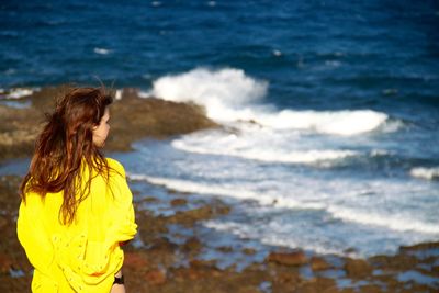 Rear view of girl standing on beach