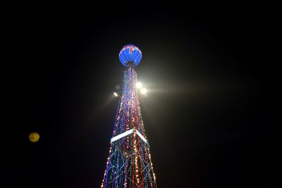 Illuminated christmas tree against sky at night