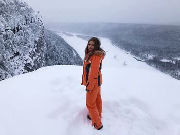 Portrait of young woman standing on snow during winter