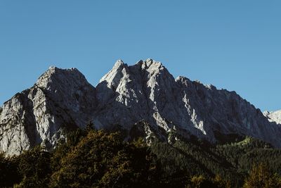 Low angle view of mountains against clear blue sky