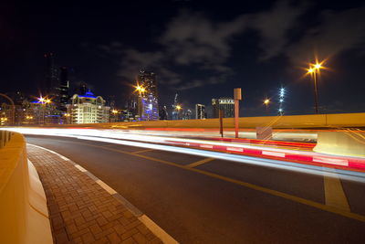 Light trails on road against sky at night