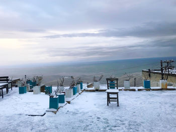 Scenic view of snow covered land and sea against sky