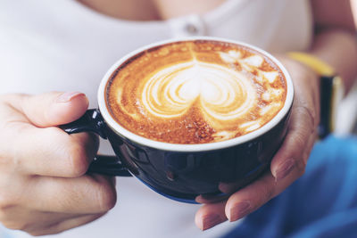 Close-up of hand holding coffee cup