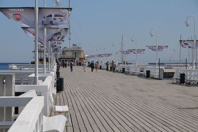 People walking in city against clear sky