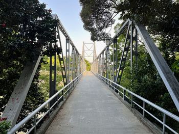 Rear view of man walking on footbridge