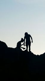 Silhouette couple standing against clear sky