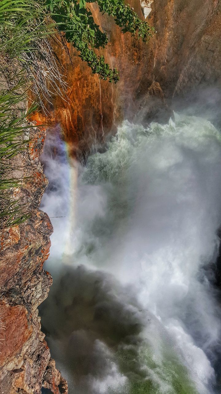 SCENIC VIEW OF WATERFALL AGAINST ROCKS