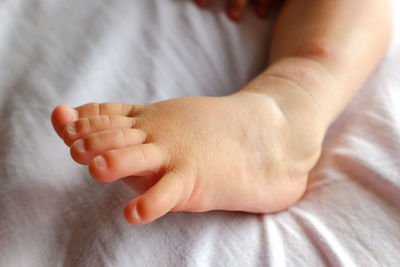 Close-up of baby hand on bed