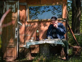 Senior man sitting near table outdoors