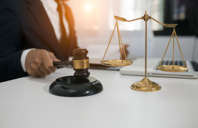 Close-up of hand holding wine glass on table