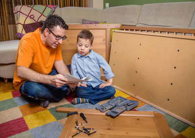Full length of boy sitting on floor at home