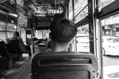 Rear view of man sitting in train