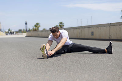 Confident young man exercising during sunny day