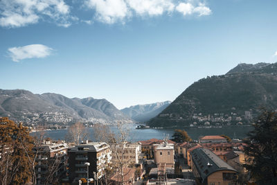 Aerial view of city by sea against sky