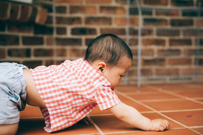 Rear view of cute boy against wall